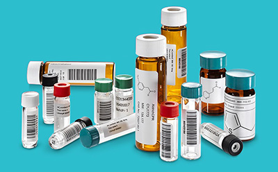 Assortment of labeled pharmaceutical vials and laboratory sample tubes arranged against a turquoise background.