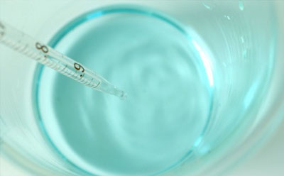 Biological Buffers A thermometer measuring the temperature of a clear blue liquid in a glass container.