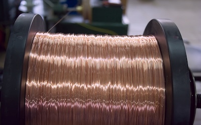 High Purity Metals in Optoelectronics 一张制造车间内铜线卷的特写照片。铜线卷绕整齐,展现出其光亮、反光的表面。