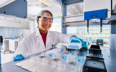Scientist switching out components in the AAW™ workstation holding a plate