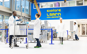 四位科学家站在实验室的不同角落工作