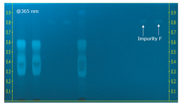 Chromatograms at long (365 nm) wavelength A thin-layer chromatography (TLC) plate, viewed under a wavelength of 365 nm after being sprayed with fluorescamine, displays a blue color. On both the right and left edges of the plate, there are 9 yellow markings, starting from the bottom and labeled from 0.1 to 0.9, each placed at intervals of 0.1 cm. The plate reveals three distinct faded bands, representing the impurities labeled D, E, and G. These bands stand out clearly against the blue background, indicating the presence and separation of these impurities.