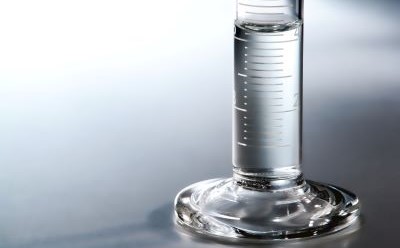白色和灰色背景上装有 40 毫升水的玻璃量筒