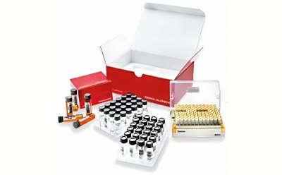 A collection of laboratory samples displayed on a white background. In the center, a large open box labeled with a red logo contains multiple rows of small glass vials filled with various substances. Surrounding the box are additional vials and a red folder, suggesting a well-organized compound screening library.