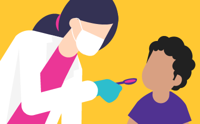 A doctor holds a spoonfull of liquid in front of a child.