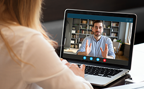 Woman looking at screen and watching a chemistry webinar on laptop