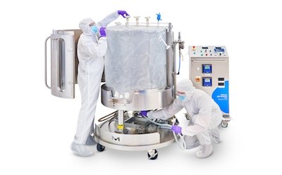 Two operators, fully gowned, installing the single-use Ultimus® Bag in the Mobius® ADC reactor