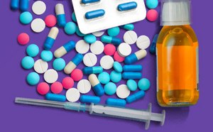 紫色背景上摆放着五颜六色的各种药品，包括蓝色、粉色和白色的各种药丸、胶囊泡罩、药液瓶和注射器。