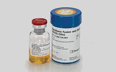 图片上有两个容器，一个是红色瓶盖的小玻璃瓶，里面装着黄色液体。标签上有“HYBRIDOMA”、“SERUM-FREE”和一些数字代码。另一个是较大的蓝色塑料容器，标有“杂交瘤融合和克隆补充剂（HFCS）（50x）”字样，并附有数字代码“B11 343 735 001”和GE Healthcare Life Sciences公司的标识。