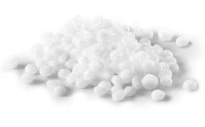 A pile of white, spherical pellets on a white background, representing caustic alkalis & bases in a solid, granular form.
