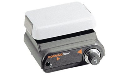 A Corning Stirrer, a laboratory equipment with a white top and grey base, equipped with control knobs and labeled ‘CORNING Stirrer’, designed for mixing solutions in a lab setting.