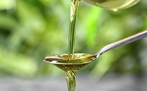 Spoon with liquid being poured over it.