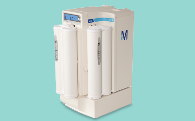 AFS<sup>®</sup> 24 clinical water purification system for direct analyzer feed 紧凑型 AFS 24 净水系统,正面有两个圆柱形滤芯,一个显示 "5.0 °C "的小型数字显示屏,侧面有一个大大的蓝色 "M "字样,背景为浅绿色。