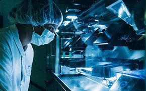 A masked scientist performing quality control